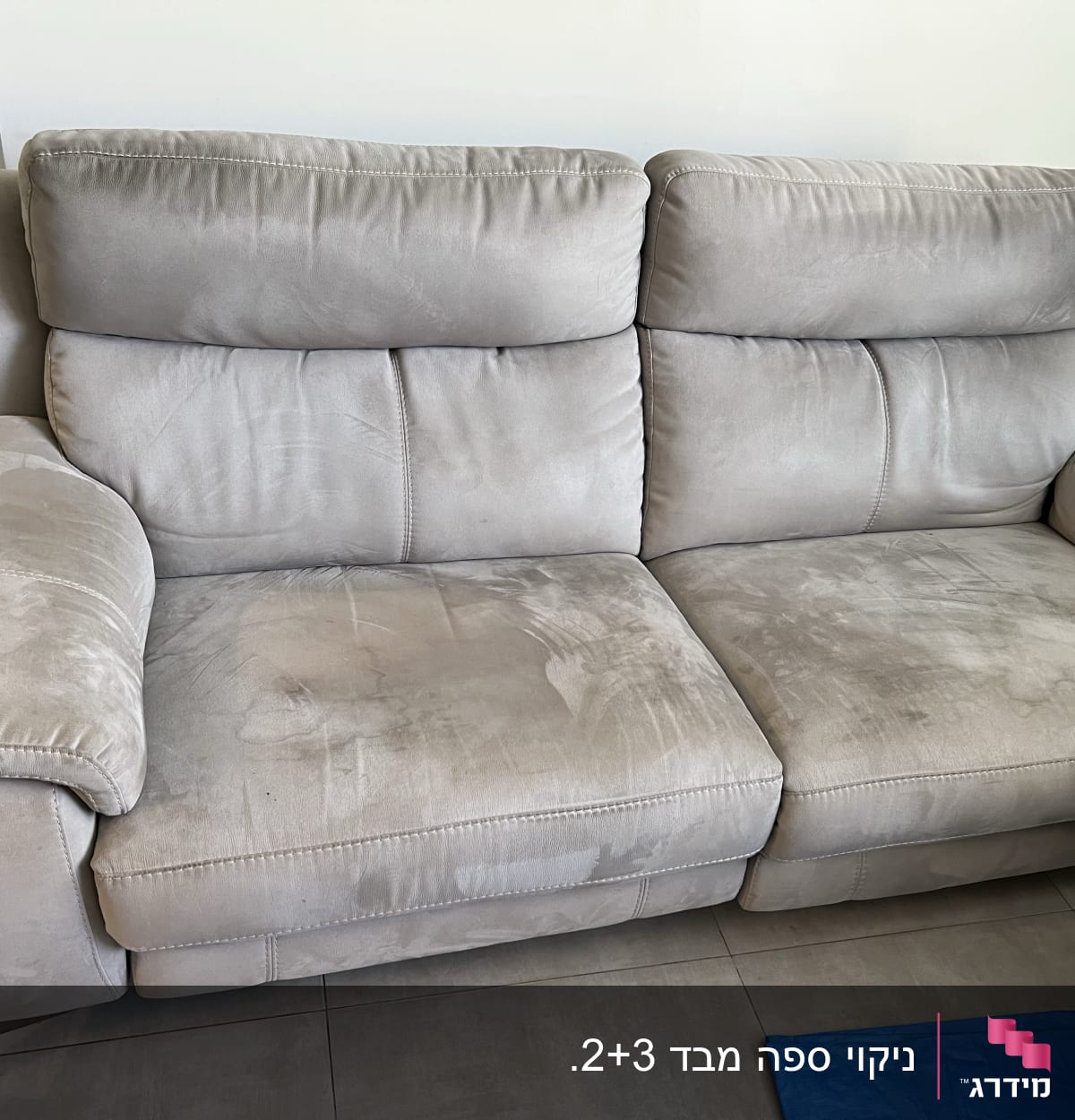 ספה אפורה עם כתמים על המושב והמשענת